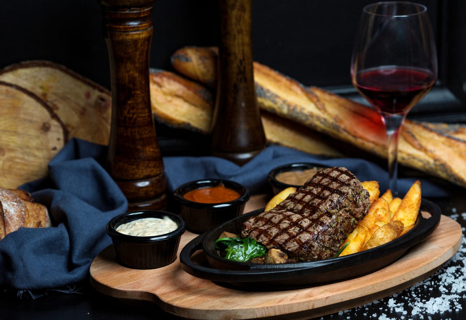 Bife grelhado servido com batatas fritas, maionese, mostarda e ketchup